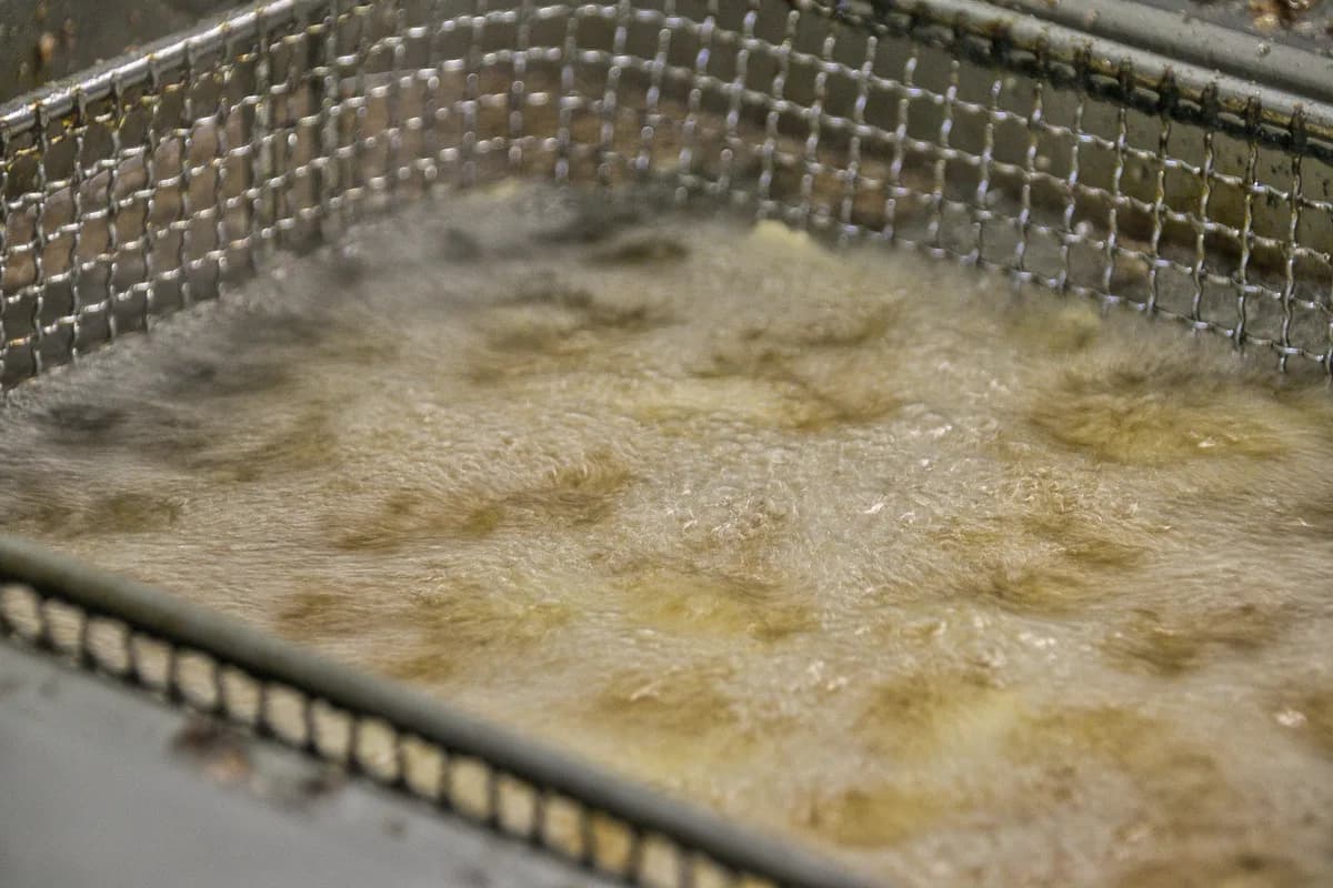 Commercial deep fryer with fresh oil in a restaurant kitchen