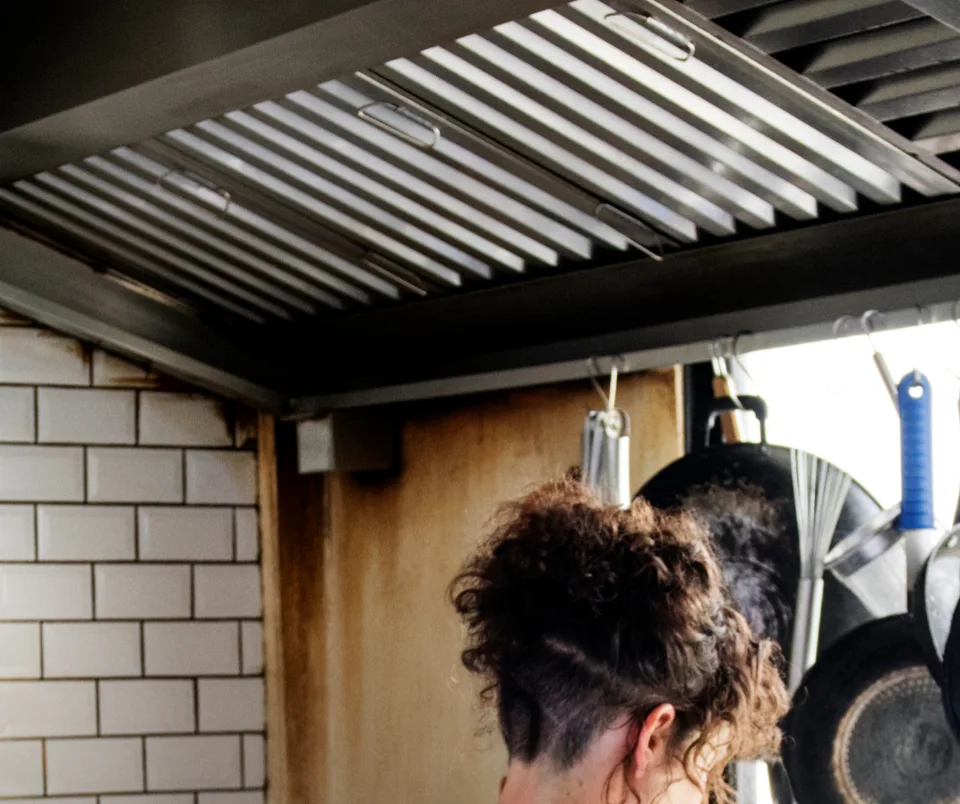 Commercial kitchen hood baffle filters removed for cleaning in restaurant