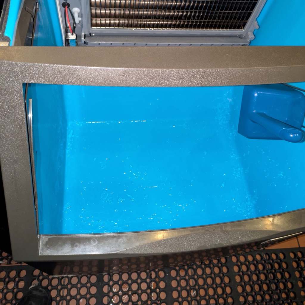 Commercial ice machine storage bin with debris before cleaning